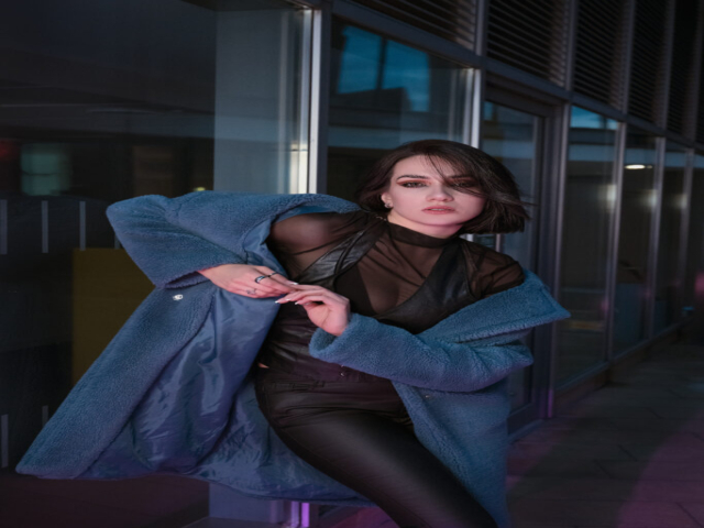 Image has a futuristic theme of dark blues with neon signs, featuring a model in centre of image