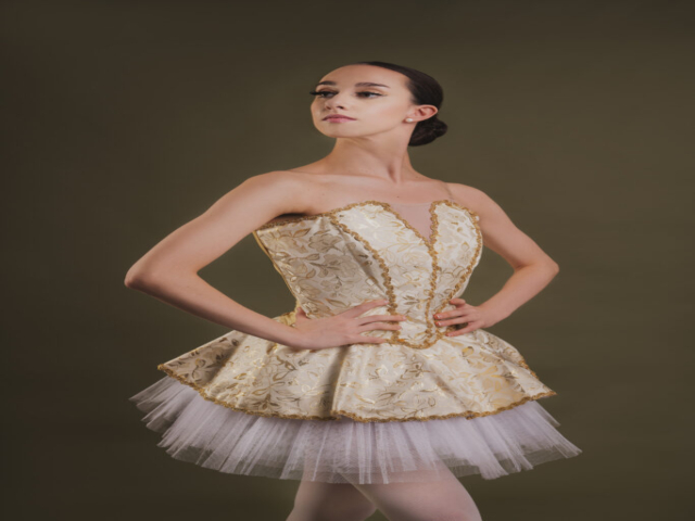 Image of Erica, a ballerina. A portrait of Erica in an ivory tutu with embroidered decorations.