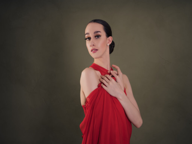 Image of Erica, a ballerina. A portrait of Erica in a red dress, in dance pose.