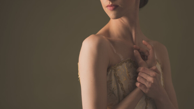 Image of Erica, a ballerina. A portrait of Erica in an ivory tutu with embroidered decorations.